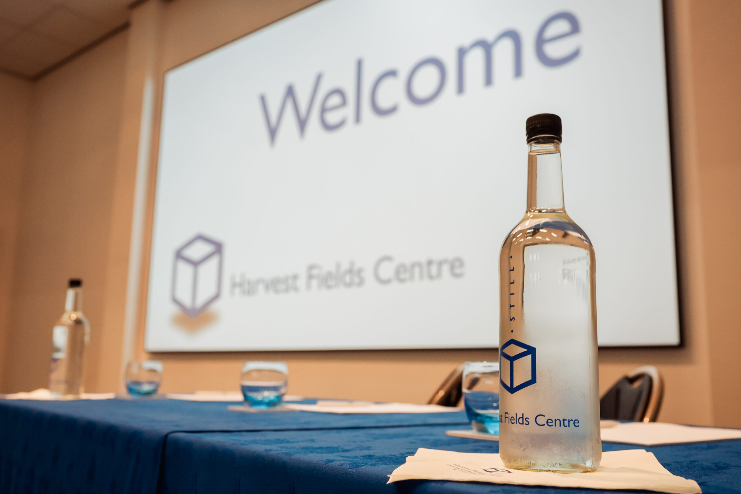 welcome-screen-conference-table-water-bottle-harvest-fields.jpg